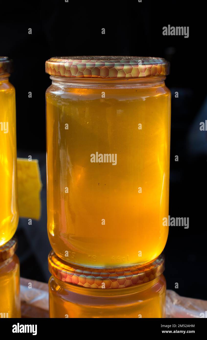 Il vasetto di vetro della piena di miele fresco con coperchio Foto Stock