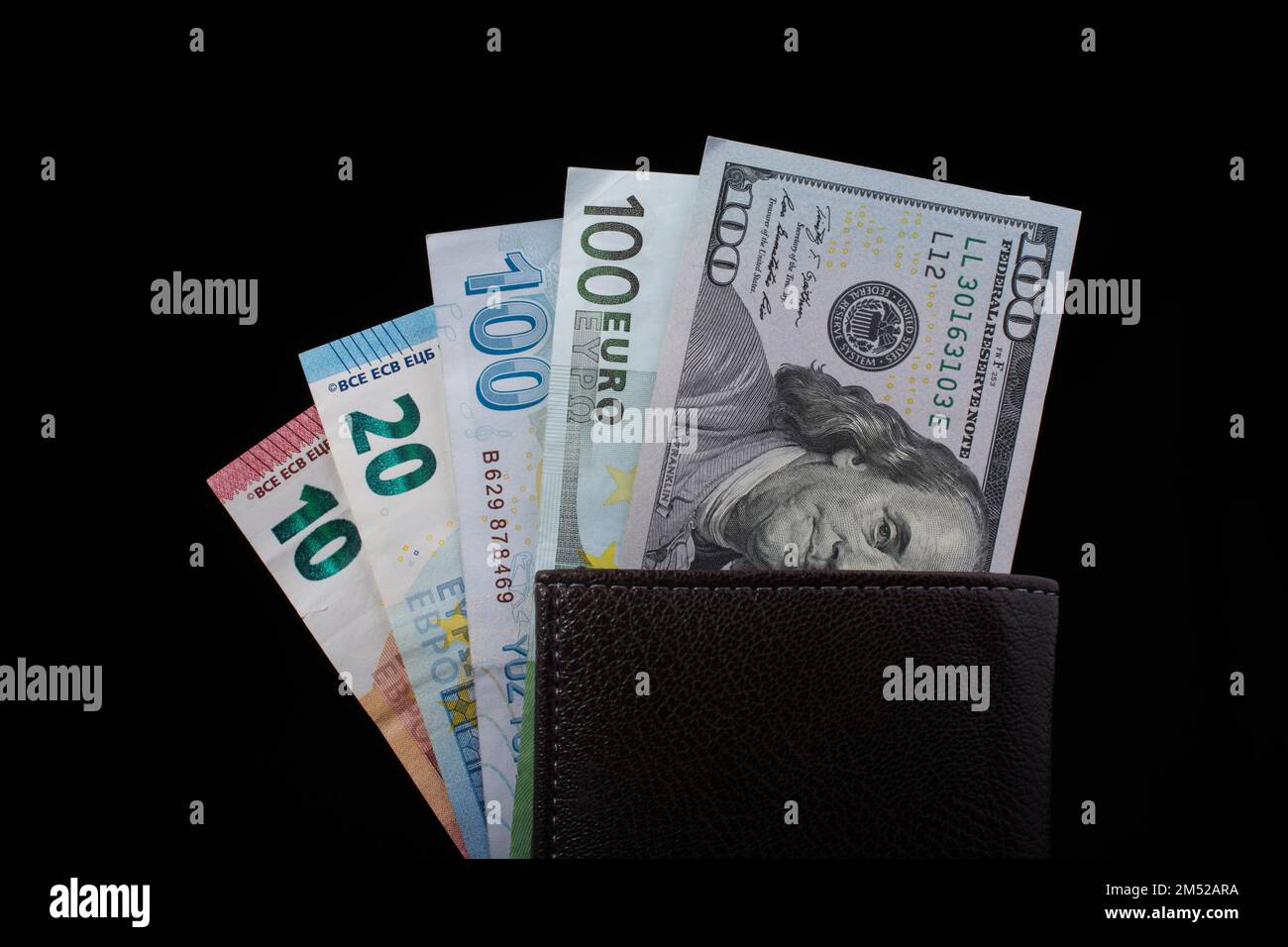 Tenere a mano le banconote in dollari americani isolate su sfondo nero Foto Stock