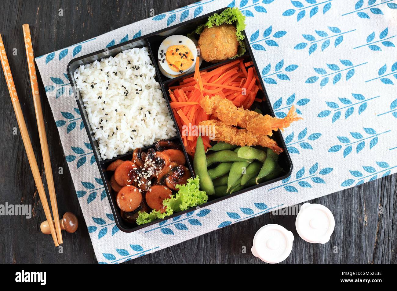 Bento Box giapponese con salsiccia Teriyaki, carota, uovo al vapore,  Nugget, Edamame, E Tempura Shrimp Foto stock - Alamy