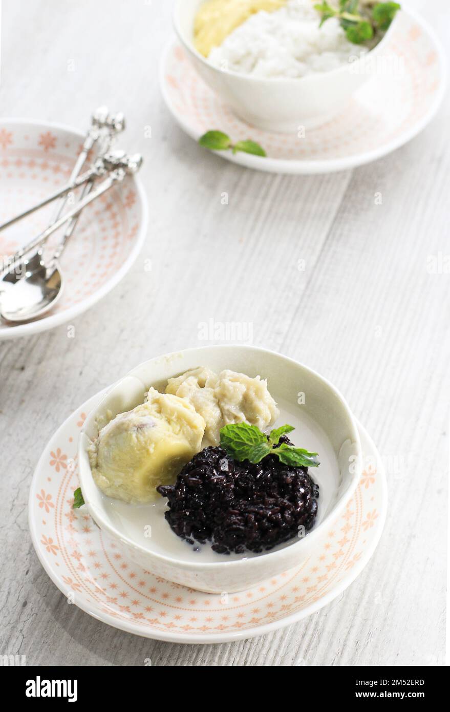 Riso sticky nero tailandese Durian con zuppa di latte di cocco, su tavolo bianco. Dessert tropicale in stile thailandese. Messa a fuoco selezionata Foto Stock