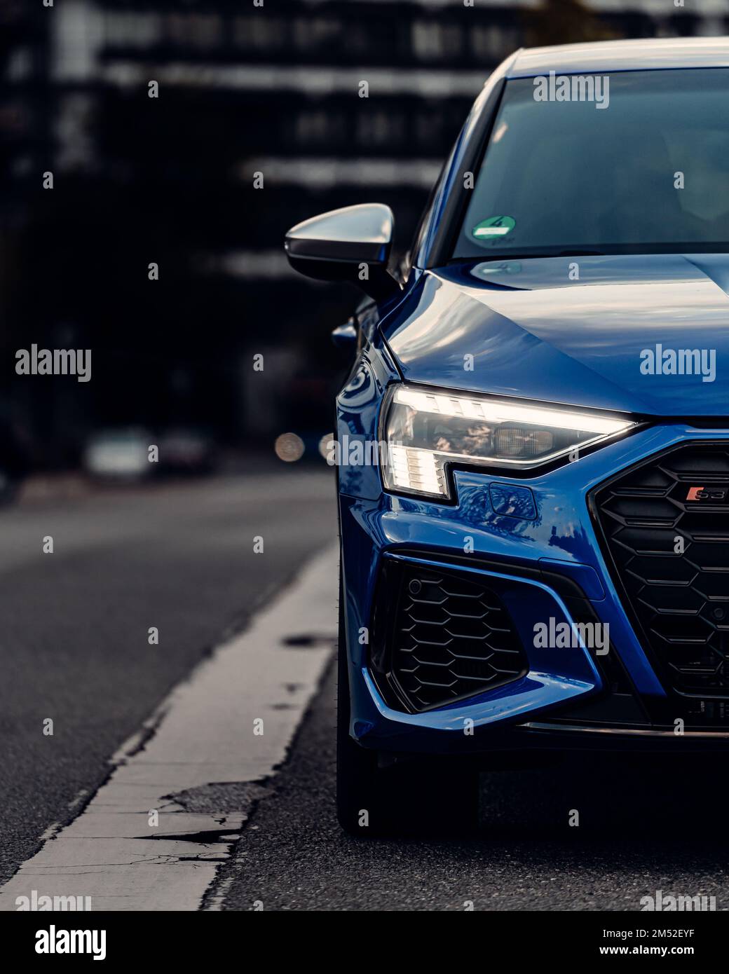 Vista frontale di uno specchio per auto sportive blu lucido con sfondo sfocato, scatto verticale Foto Stock