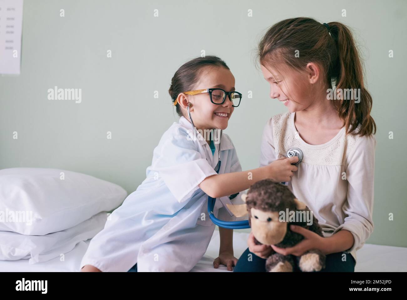 I migliori amici si si guardano. una bambina che finge di essere un medico mentre esamina la sua amica. Foto Stock