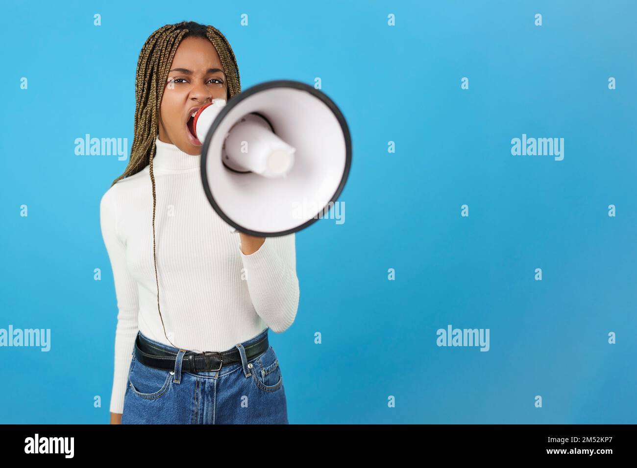 Donna africana arrabbiata che protesta mentre usa un altoparlante Foto Stock