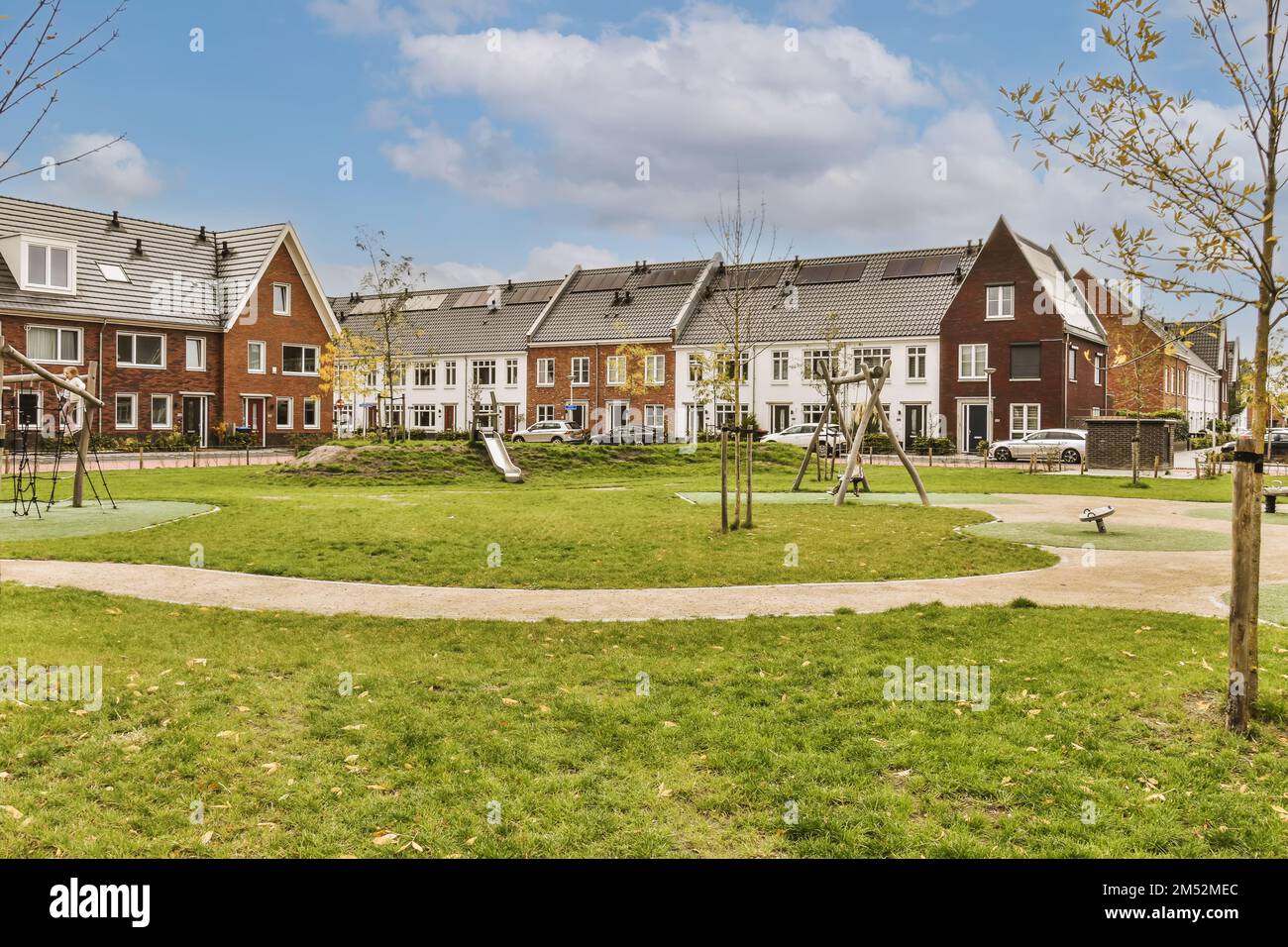 alcune case che si trovano nello stesso quartiere, una è in mattoni rossi e gli altri edifici sono bianchi con tetti grigi Foto Stock