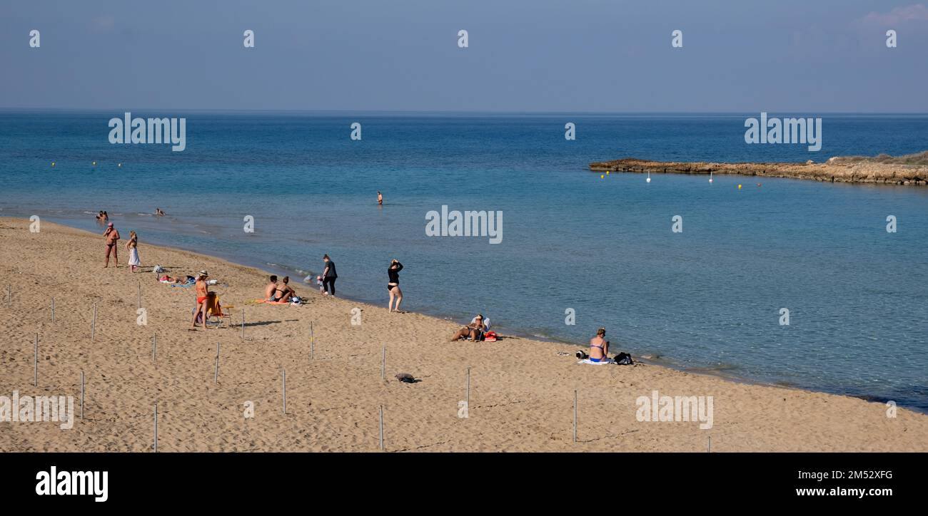 Turisti che godono vacanze autunnali, relax, nuoto al sole. Protaras fico baia Cipro Foto Stock