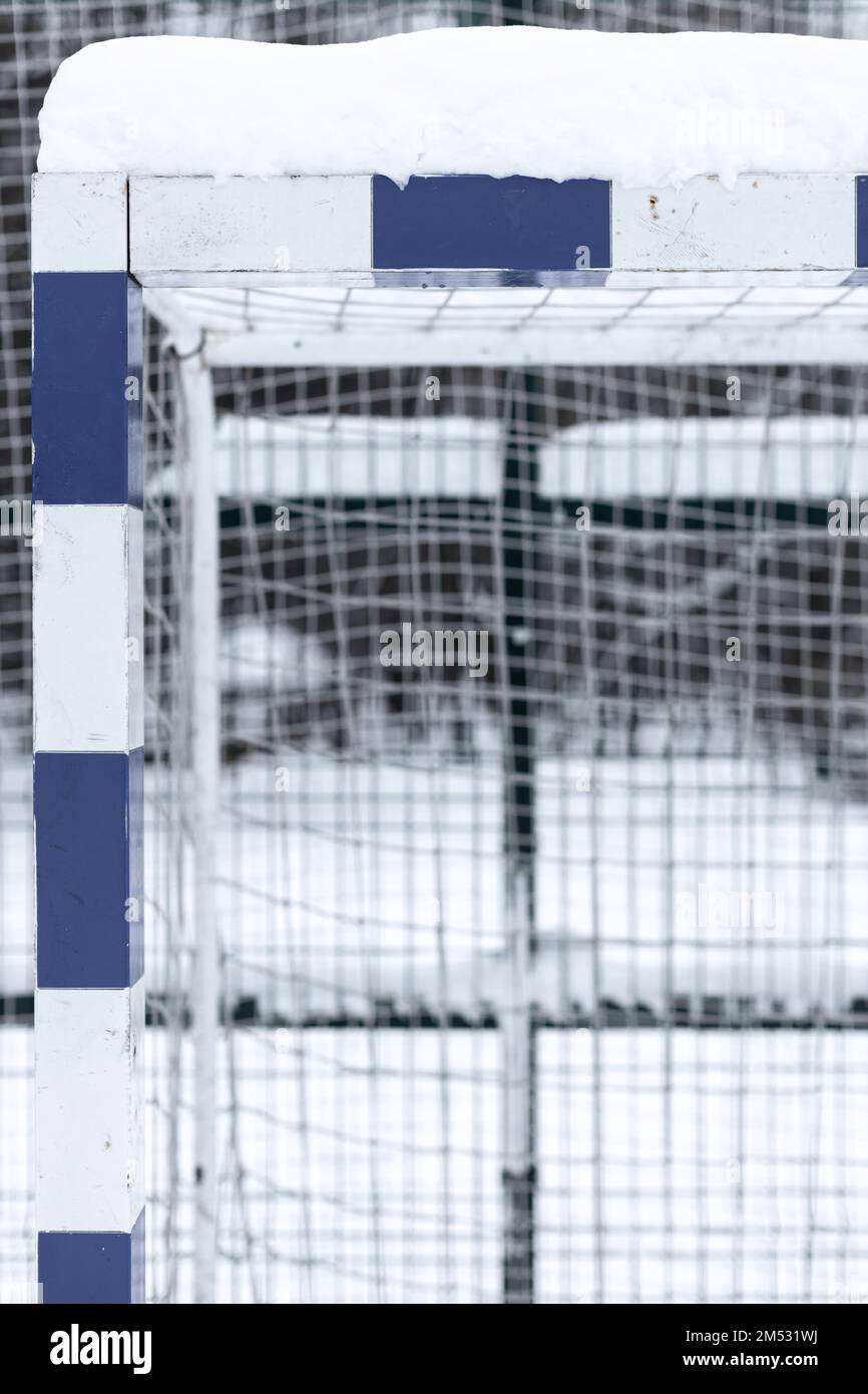 calcio gol coperto di neve in inverno. frammento di gol calcistico. post obiettivo di calcio. palo da calcio coperto di neve. Foto Stock