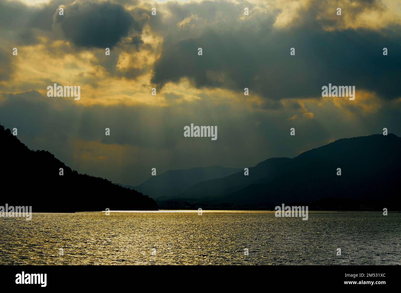 Tramonto a Hiroshima Bay, Seto Inland Sea, tra l'isola di Itsukushima e la città di Hatsukaichi. Prefettura di Hiroshima, Giappone. Foto Stock