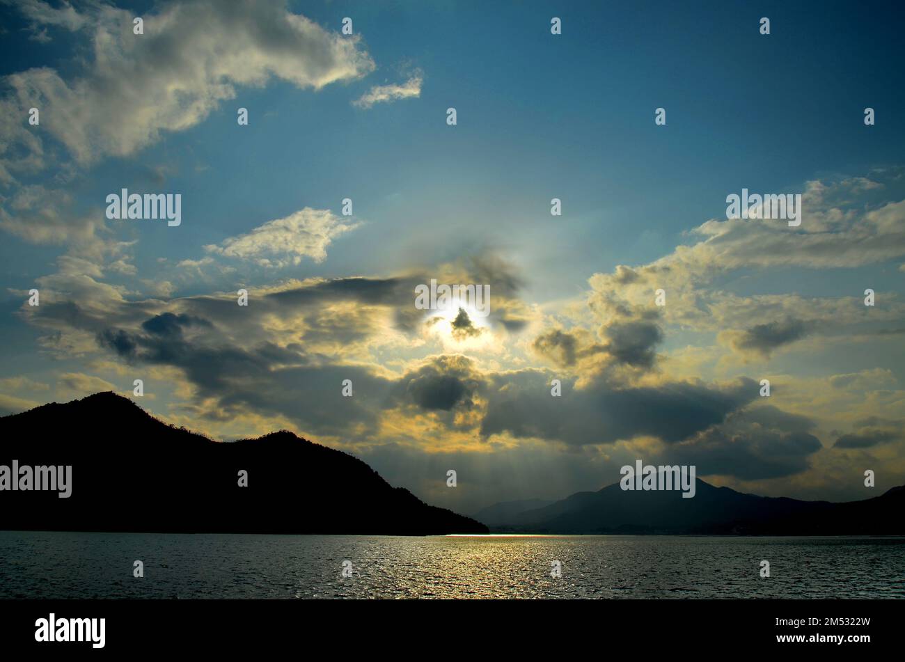 Tramonto a Hiroshima Bay, Seto Inland Sea, tra l'isola di Itsukushima e la città di Hatsukaichi. Prefettura di Hiroshima, Giappone. Foto Stock
