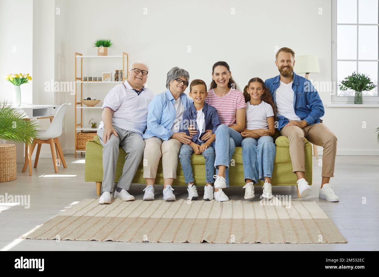 La famiglia è molto felice e si siede sul divano in una camera accogliente Foto Stock