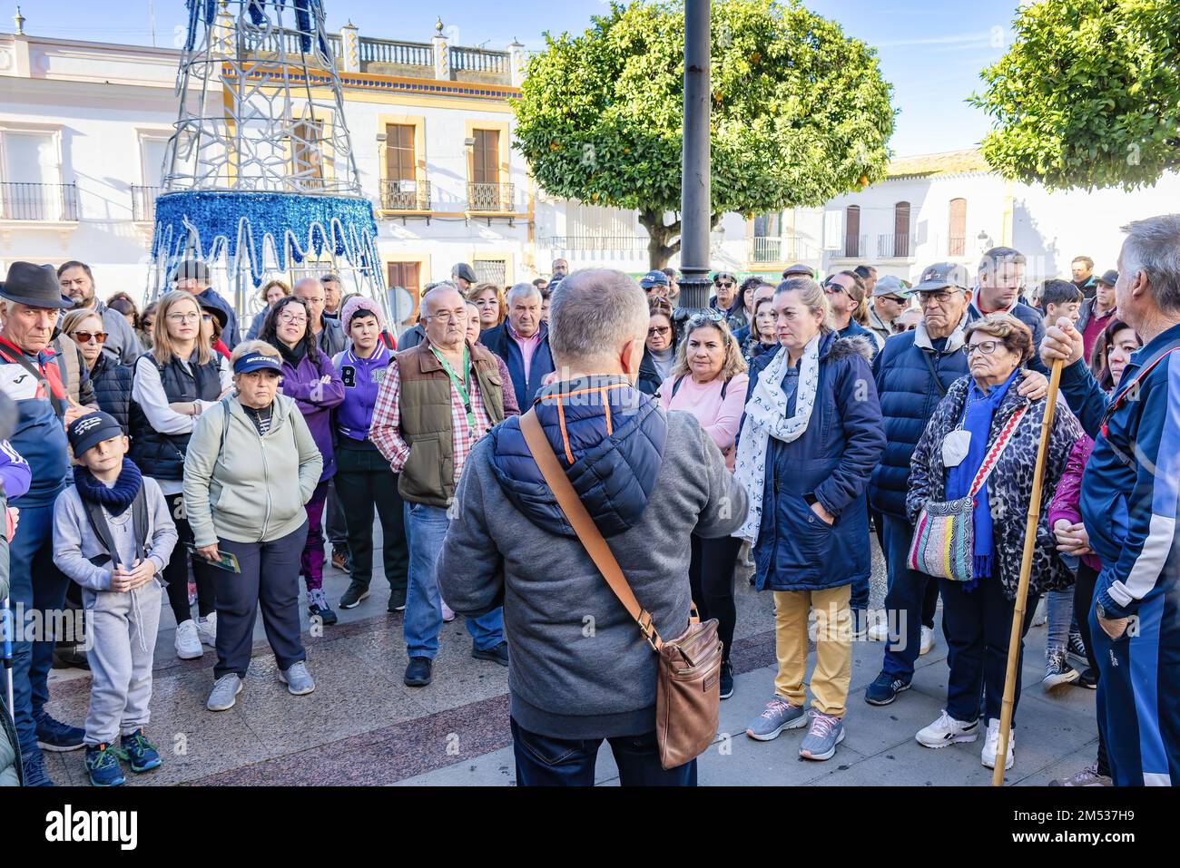Huelva, Spagna - 4 dicembre 2022: Un gruppo di turisti che iniziano una visita culturale guidata al villaggio di Beas e le fabbriche circostanti e industr Foto Stock