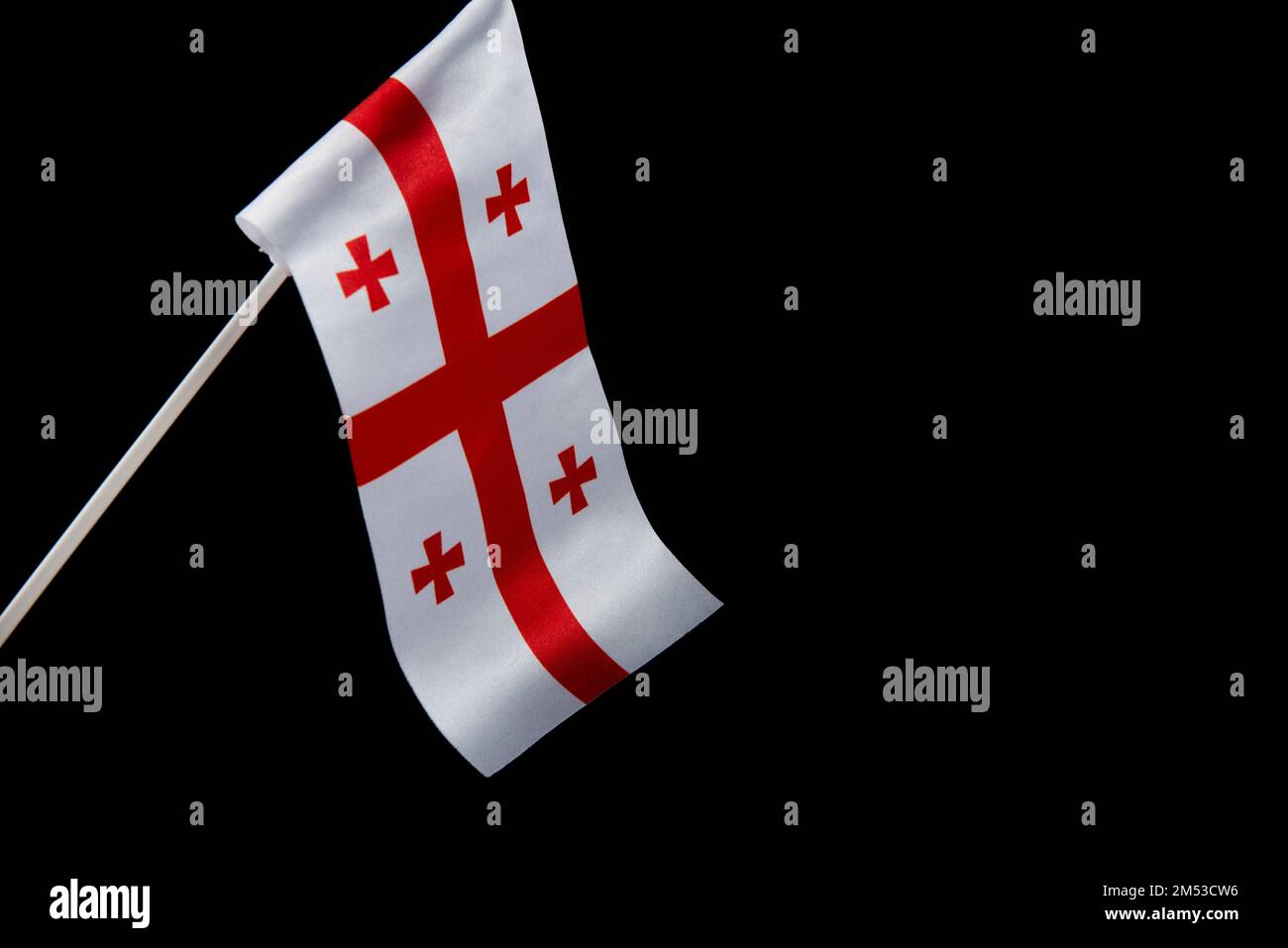 La bandiera della Georgia su uno sfondo nero si sviluppa e vola ondeggiando nel vento Foto Stock