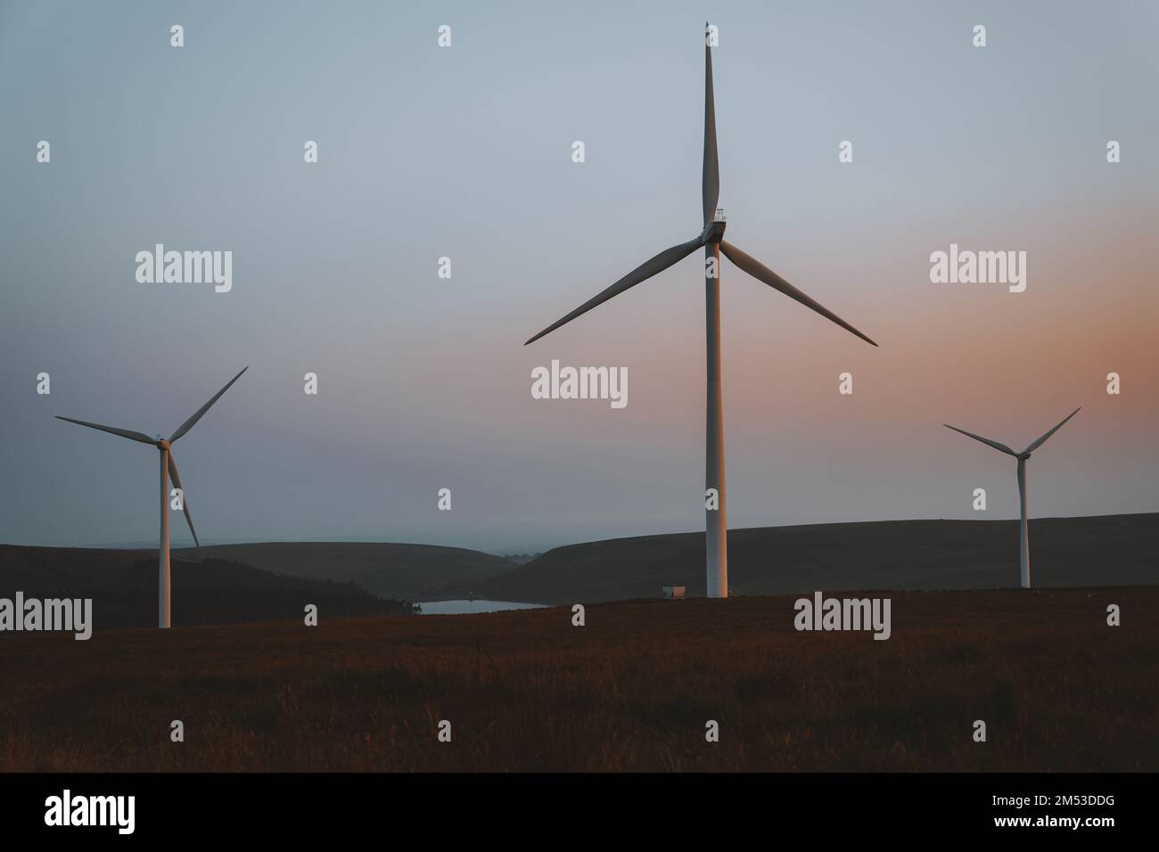 Turbine eoliche al tramonto. Fattoria eolica. Fonti di energia rinnovabili sostenibili, effetti sul concetto di ambiente. Galles del Sud, Regno Unito Foto Stock