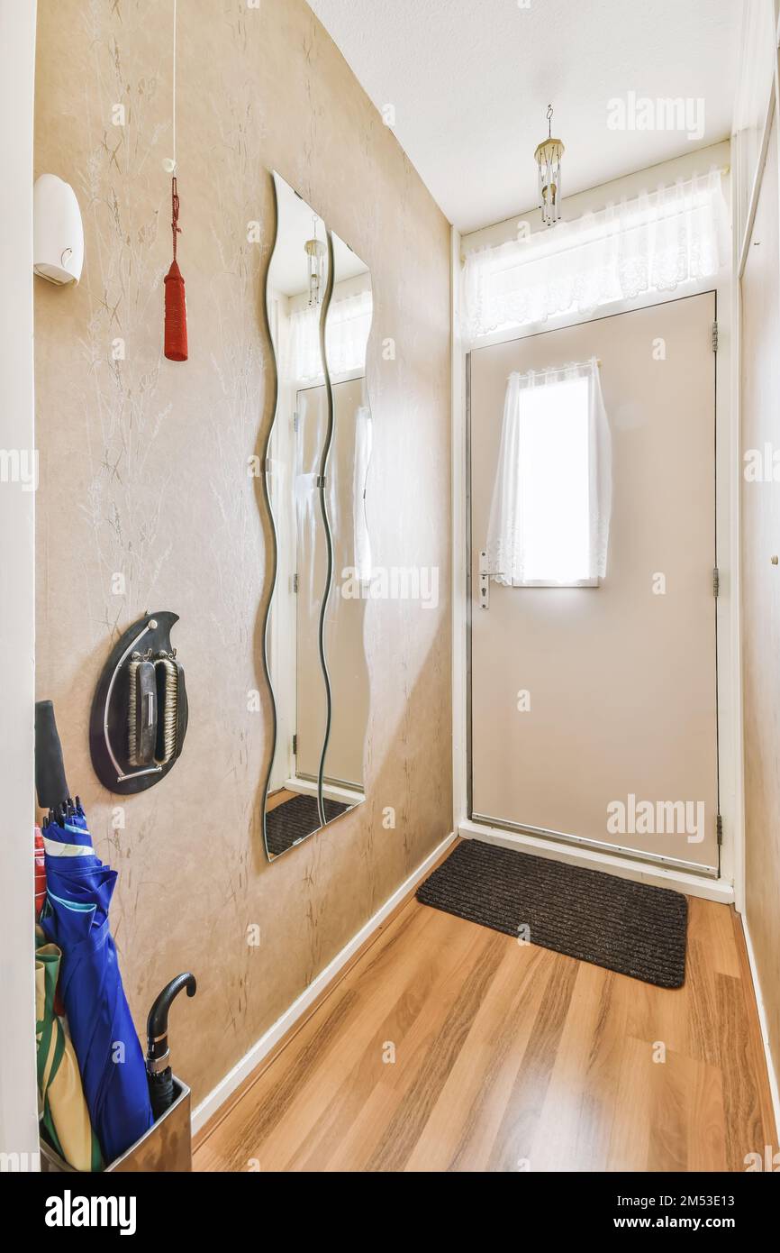 questa piccola camera dispone di un bagno con pavimenti in legno e specchi montati a parete sopra gli articoli da toeletta Foto Stock