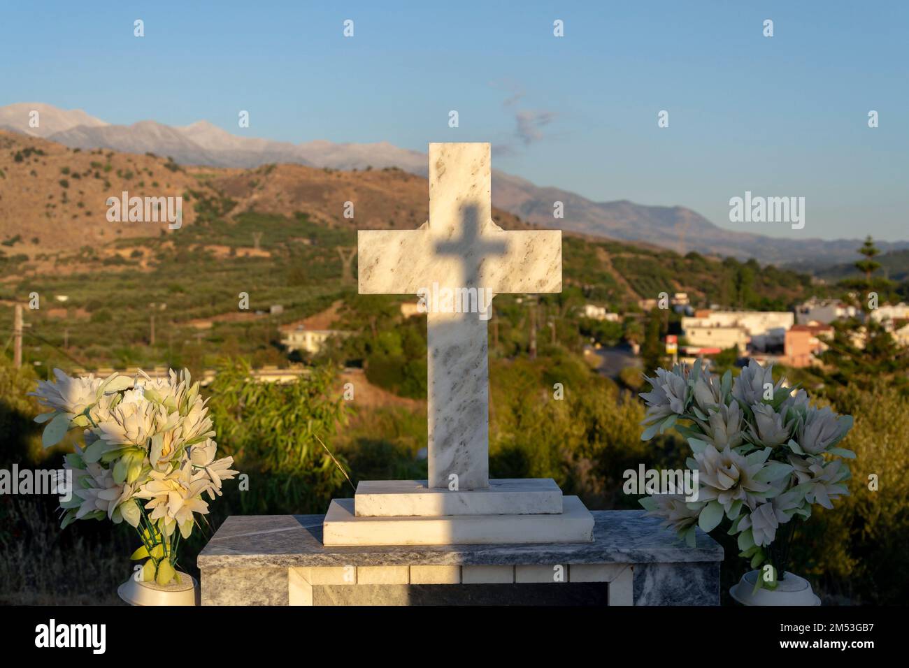 Croce su una tomba in un cimitero greco all'alba Foto Stock