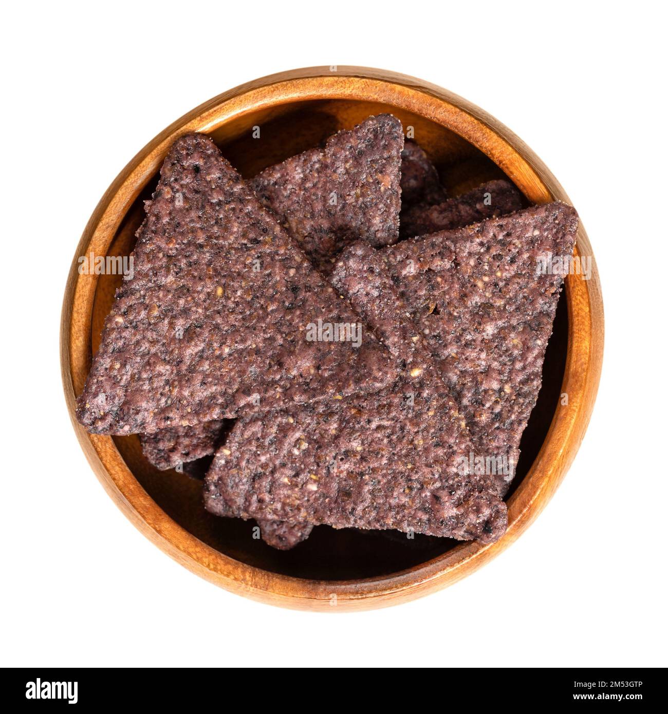 Tortilla blu in una ciotola di legno. Snack, a base di tortillas di mais blu, tagliato a spicchi a forma di triangolo, fritto in olio e leggermente salato. Foto Stock
