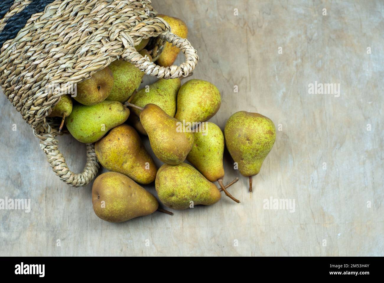 Pere in cesto su uno sfondo di legno. Raccolta di frutta. Autunno ancora vita. Pear Variety Bera Conference. Cibo vitaminico. Foto Stock