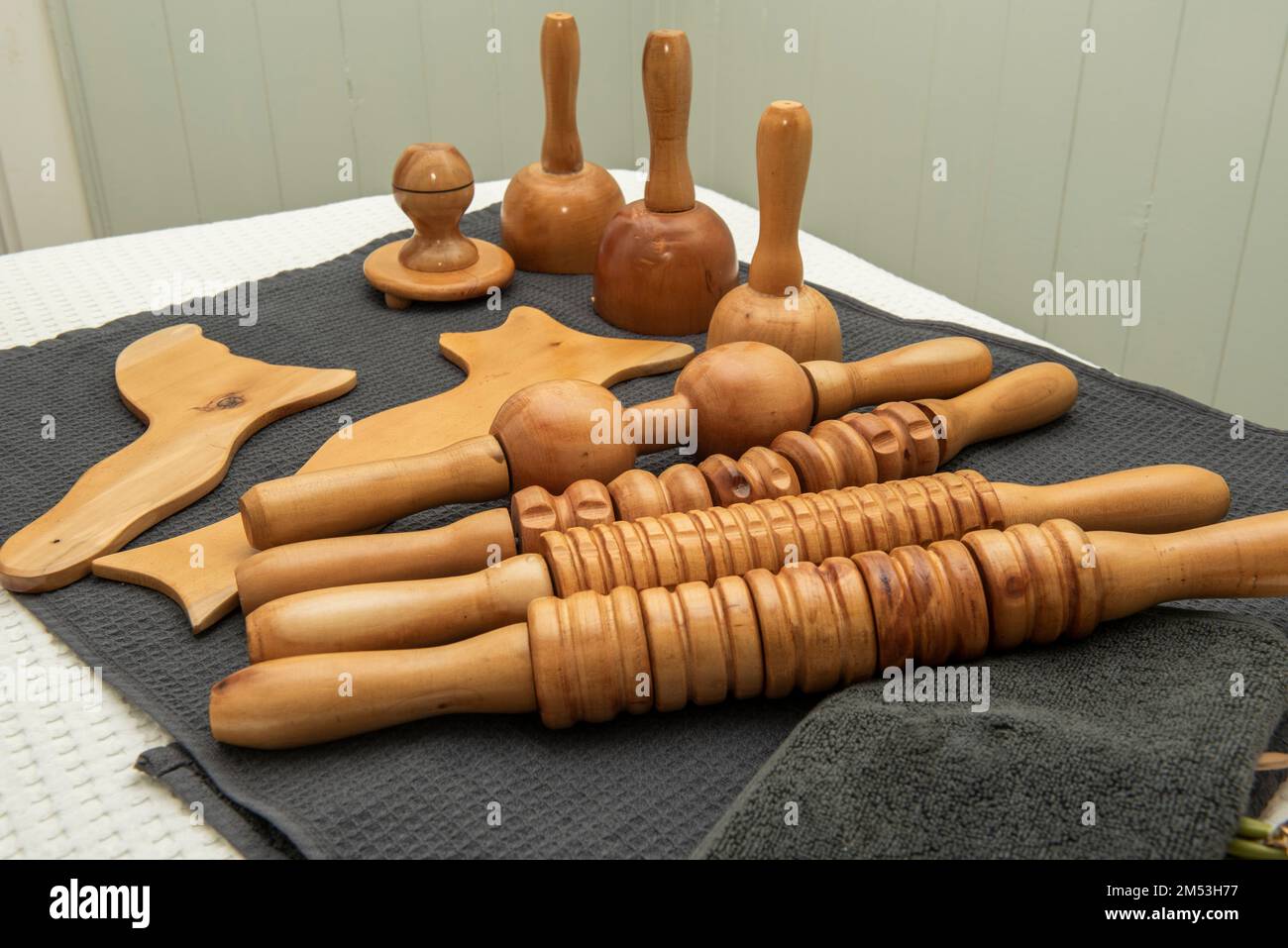 Rulli e accessori in legno per trattamenti di legno su asciugamano grigio Foto Stock