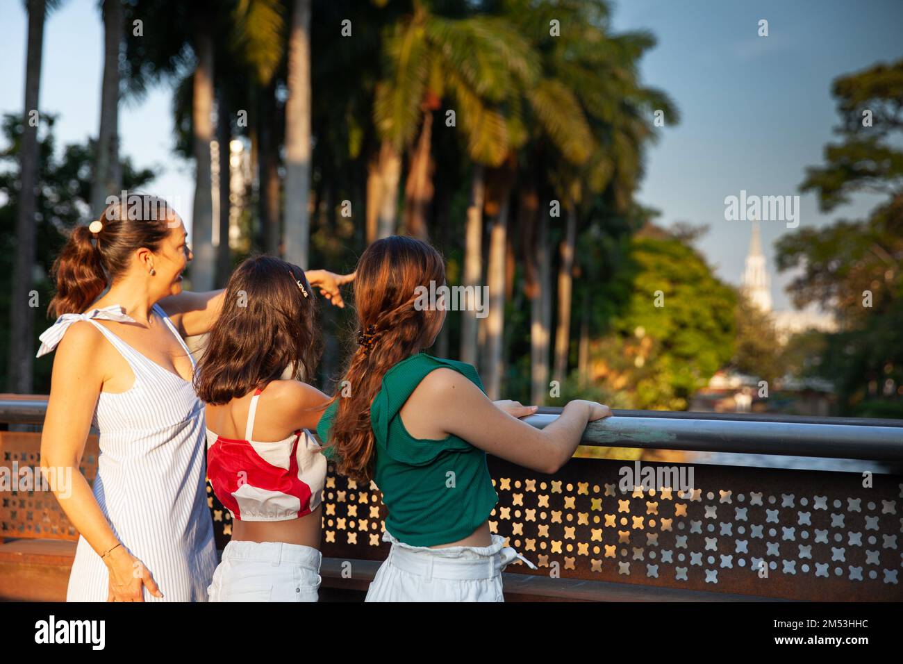 Turisti in uno dei ponti lungo il Cali River Boulevard nella città di Cali in Colombia. Concetto di viaggio per madre e figlie adolescenti. Felice Foto Stock