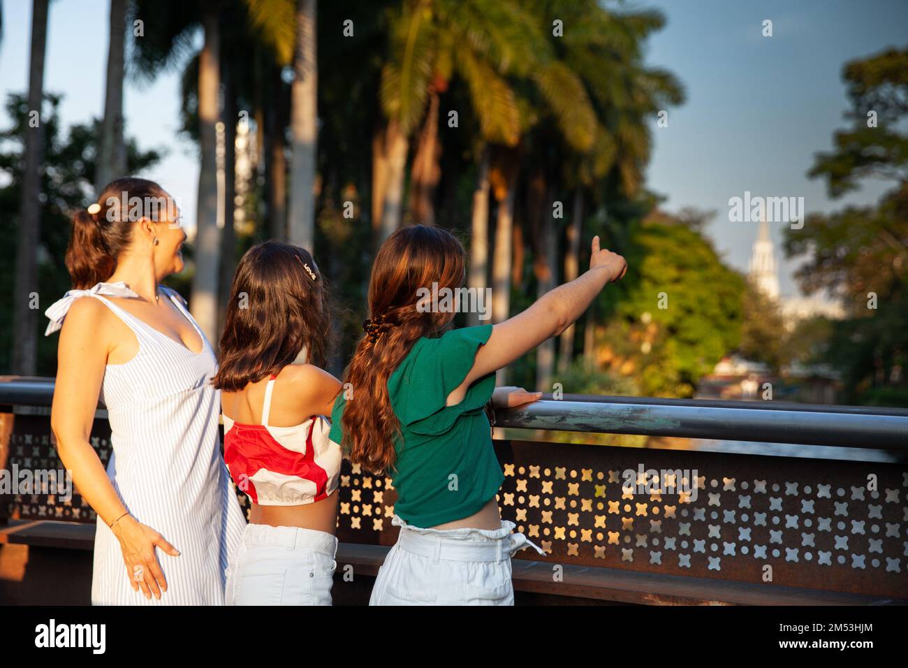 Turisti in uno dei ponti lungo il Cali River Boulevard nella città di Cali in Colombia. Concetto di viaggio per madre e figlie adolescenti. Felice Foto Stock