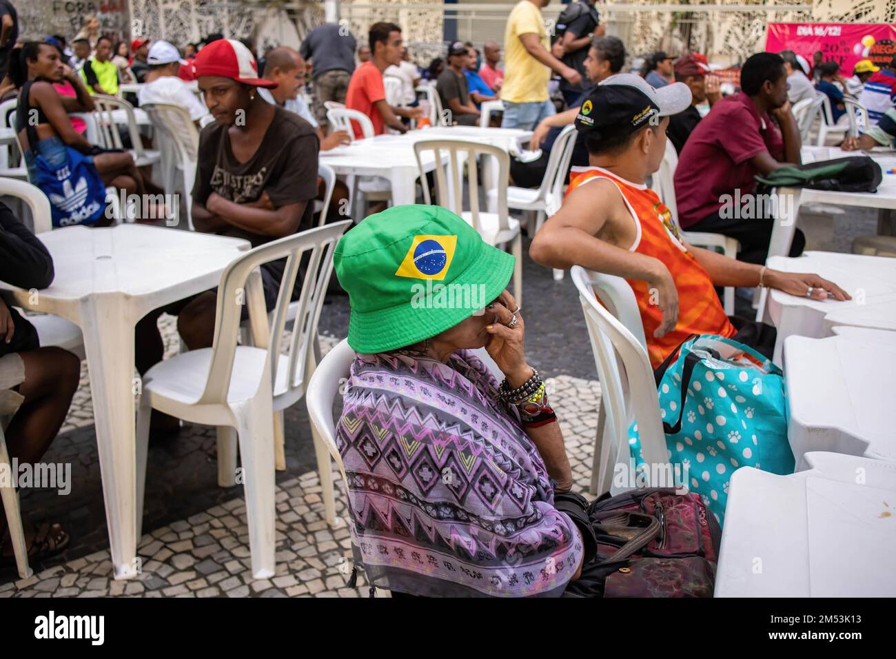 Una donna con un cappello con l'immagine della bandiera brasiliana si siede in attesa di una cena di beneficenza la notte di Natale. Cena di Natale per i senzatetto nel centro di Rio de Janeiro. 150 volontari sotto la chiesa Battista mobilitati in piazza Largo de Carioca per servire la cena di Natale per le persone che vivono per le strade del centro di Rio de Janeiro. Per 15 anni la chiesa Battista ha organizzato questo evento per i senzatetto. Nella seconda città più grande del Brasile, circa 15.000 persone vivono per strada senza casa. (Foto di Antonio Cascio/SOPA Images/Sipa USA) Foto Stock