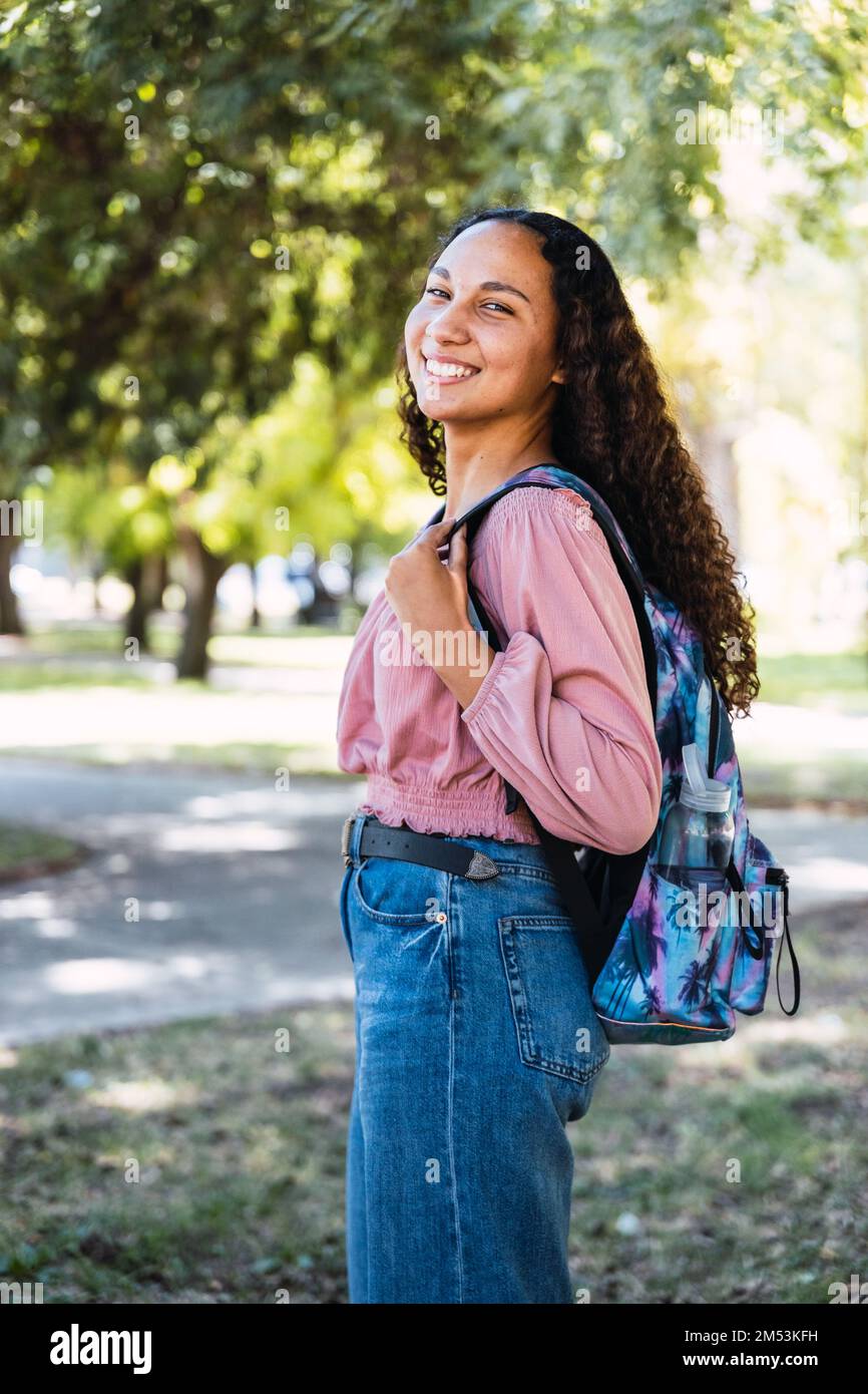 Felice giovane studentessa latina in piedi nel parco. Fiducia in se stessi. Generazione centenaria Foto Stock