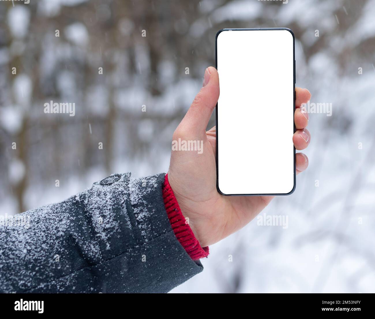 Telefono cellulare, smartphone schermo mockup in mano in inverno freddo con neve. Foto di alta qualità Foto Stock