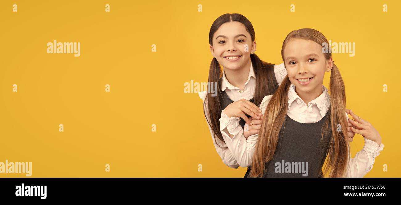 Scuole ragazze amici. Cura e preoccupazione, ritorno a scuola. I bambini felici indossano uniformi formali. Manifesto orizzontale isolato della studentessa della scuola. Banner Foto Stock