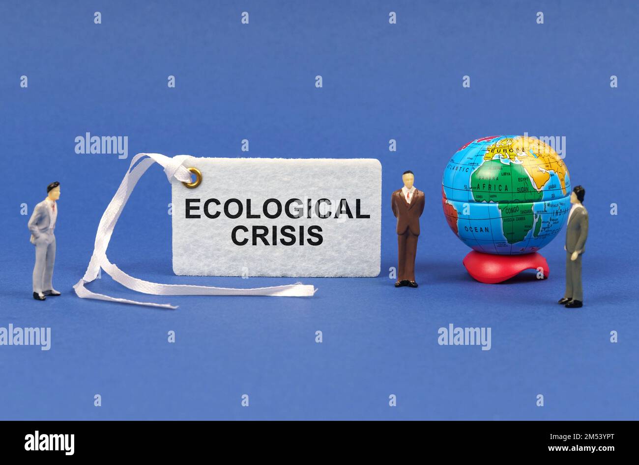 Concetto ecologico. Sulla superficie blu ci sono figurine di persone, un globo e un piatto bianco con l'iscrizione - crisi ecologica Foto Stock