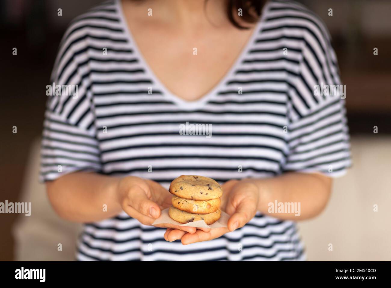 Una giovane donna tiene un biscotto appena sfornato Foto Stock