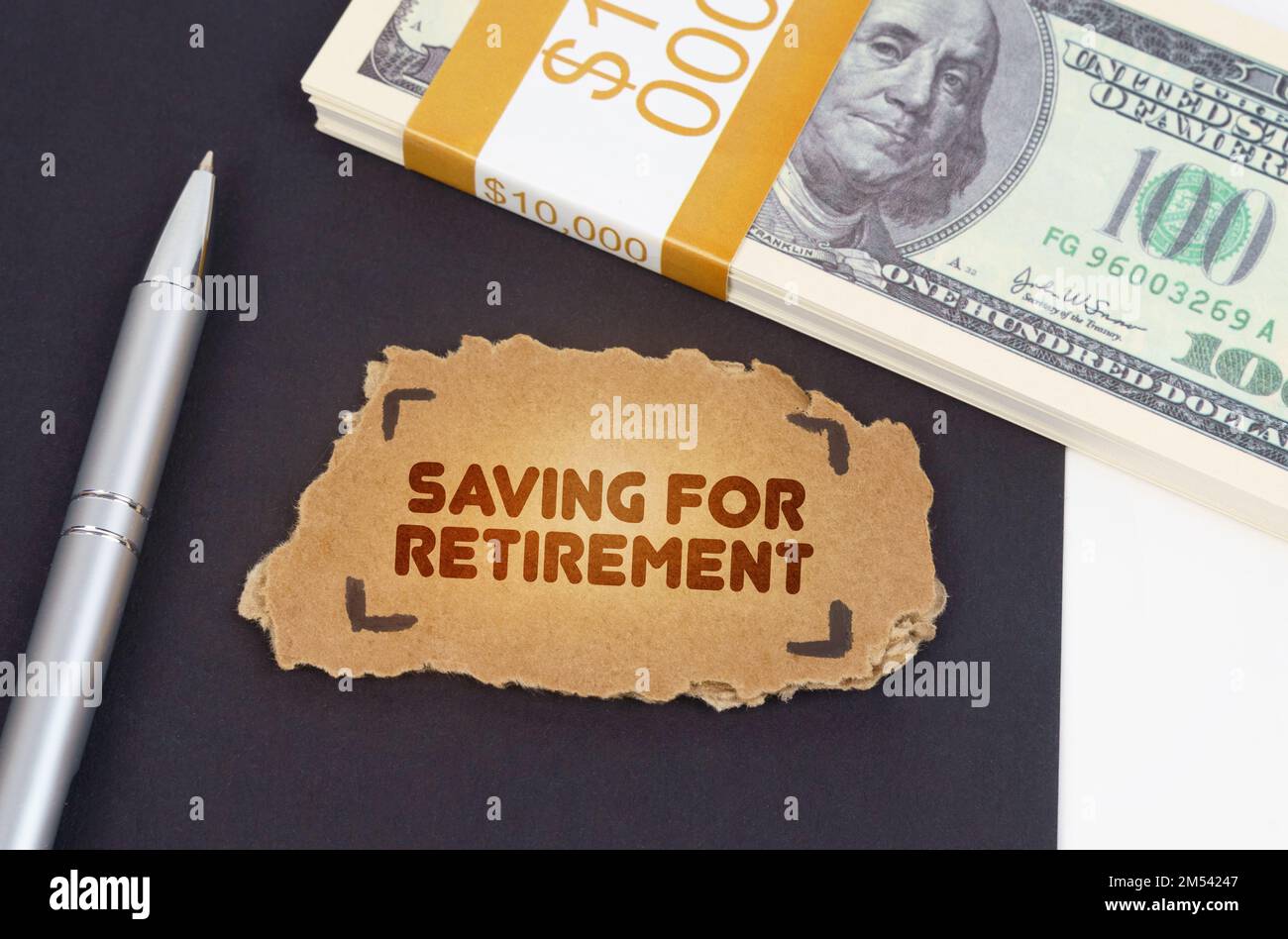 Concetto aziendale. Sulla tabella sono i dollari, una penna e un cartoncino con l'iscrizione - risparmio per pensionamento Foto Stock