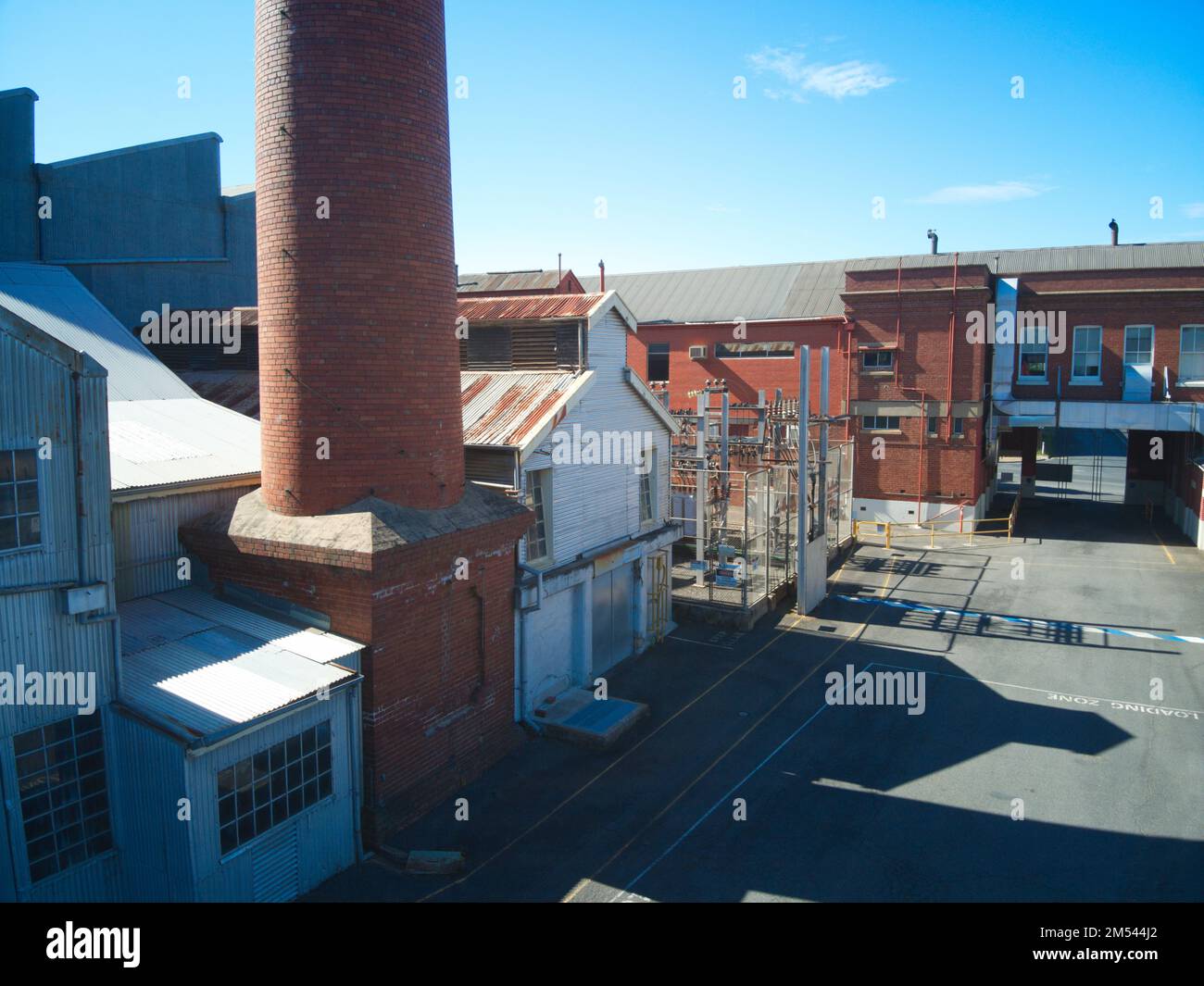 Vista aerea esterna dell'edificio della fabbrica che mostra il camino della fabbrica, gli edifici in mattoni e lo stoccaggio del magazzino, Castlemaine, Victoria, Australia. Foto Stock