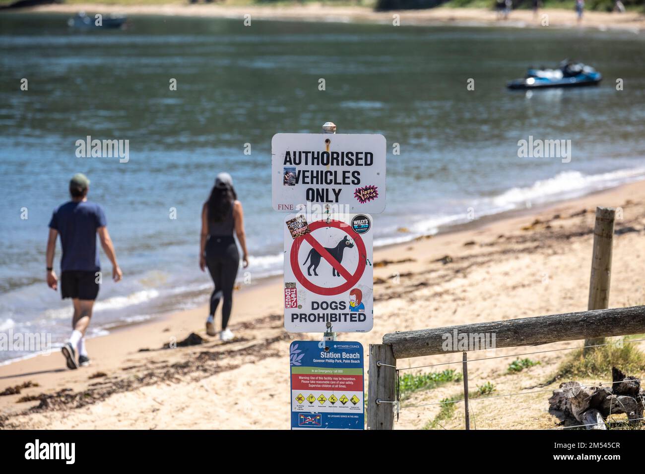 Coppia che cammina lungo Snapperman Beach a Palm Beach Sydney, oltrepassa l'insegna dei parchi nazionali per non avere cani e veicoli non autorizzati, Australia Foto Stock
