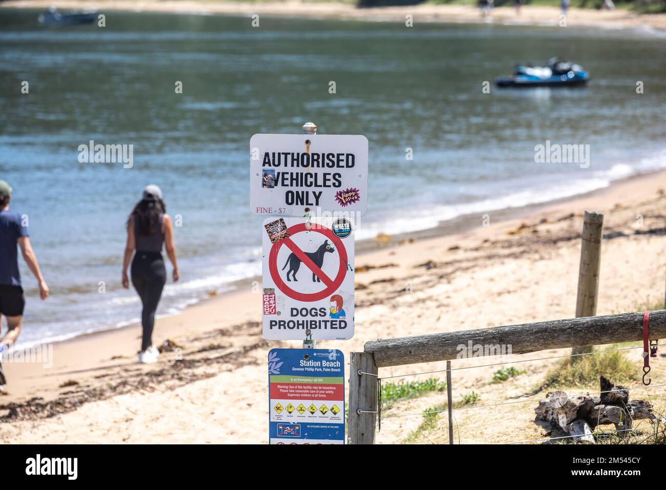 Coppia che cammina lungo Snapperman Beach a Palm Beach Sydney, oltrepassa l'insegna dei parchi nazionali per non avere cani e veicoli non autorizzati, Australia Foto Stock