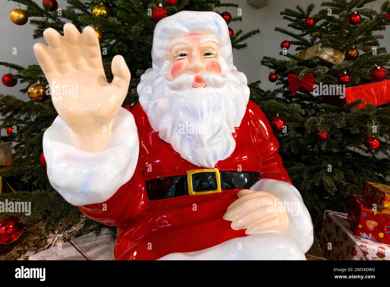 Mano che si agita, Babbo Natale, San Nicholas di fronte agli alberi decorati di Natale, figura di plastica, decorazione di Natale nel supermercato, shopping Foto Stock