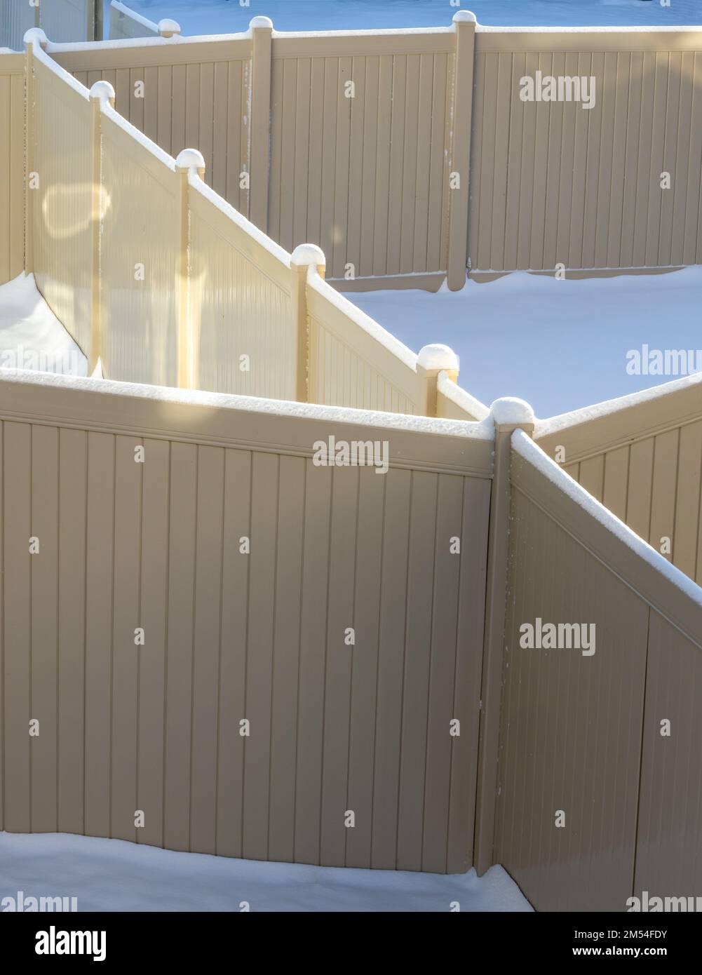 Geometria fence. Recinzione in plastica per i cortili posteriori sotto neve fresca Foto Stock