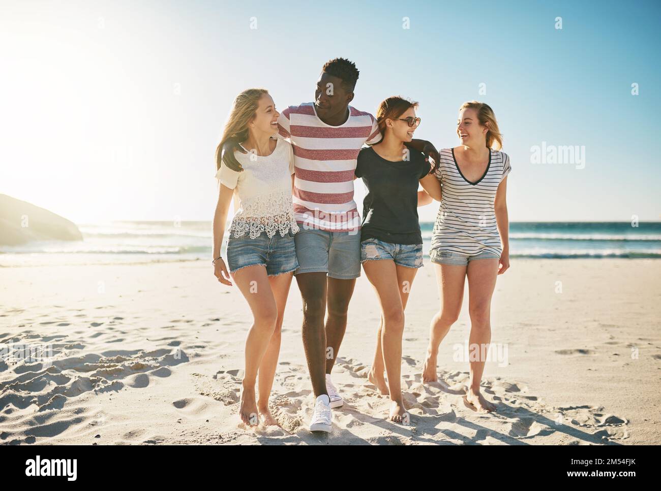 Giorni di sole con alcuni amici veramente grandi. un gruppo felice di amici che si godono una giornata insieme in spiaggia. Foto Stock