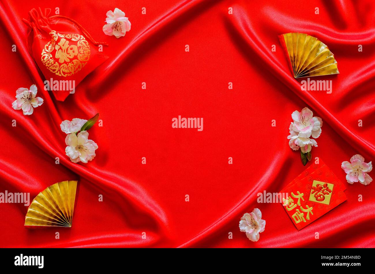 Sfondo di tessuto di raso rosso con borsa rossa (parola media ricchezza), e pacchetti busta rossa o ang bao (parola media ricchezza, fortunato) con i fan d'oro per il cinese Foto Stock