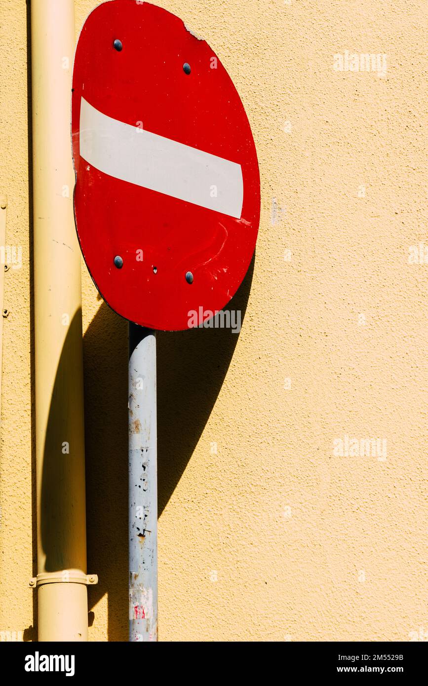 Un colpo verticale di rosso senza entrata segno palo appoggiato su edificio pesca Foto Stock