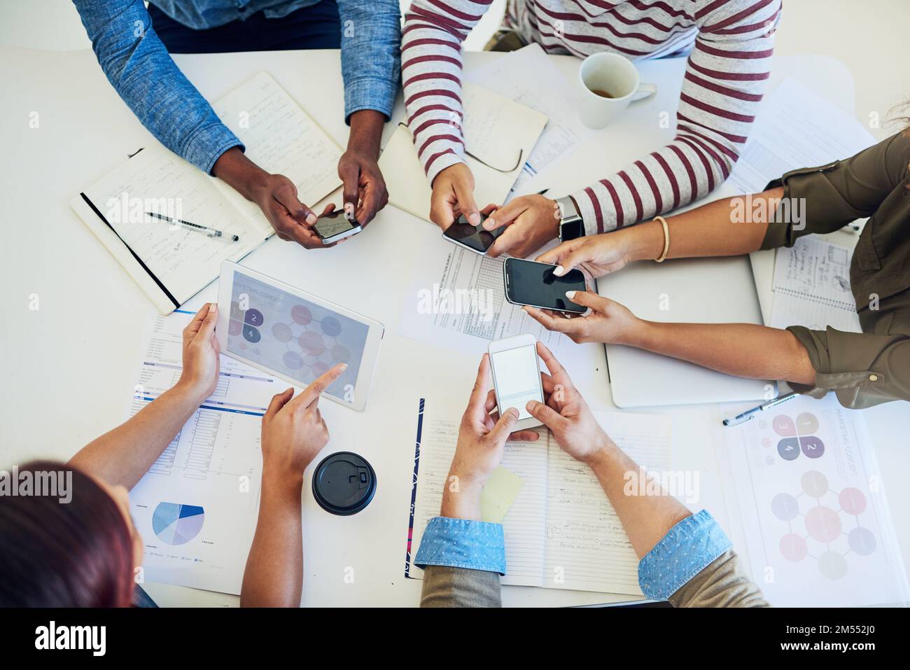 Dispositivi intelligenti che consentono di svolgere le attività. un gruppo di colleghi che utilizzano dispositivi intelligenti durante una riunione al lavoro. Foto Stock