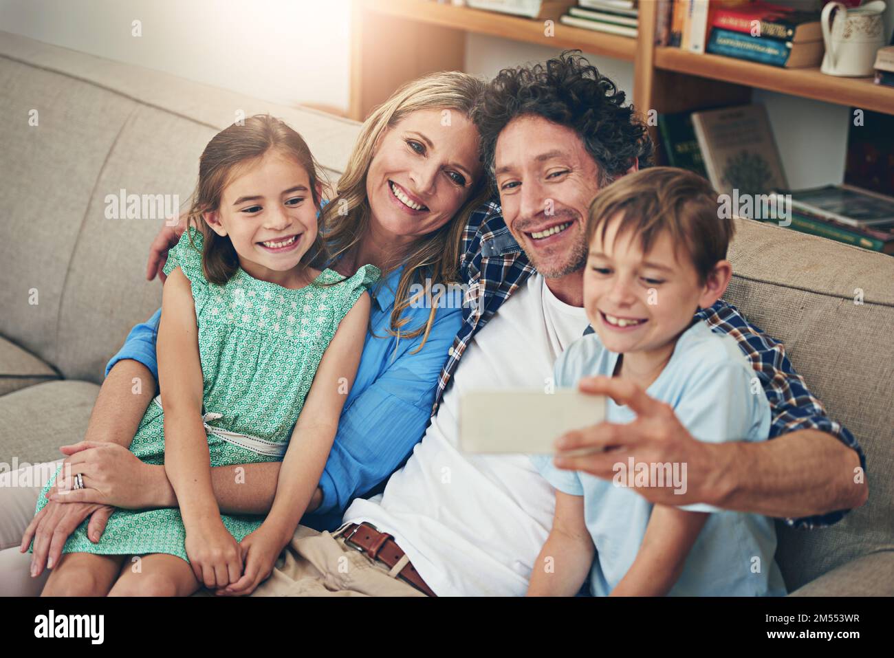 Momento perfetto per un selfie di famiglia. una famiglia felice che porta un selfie insieme su un telefono cellulare a casa. Foto Stock