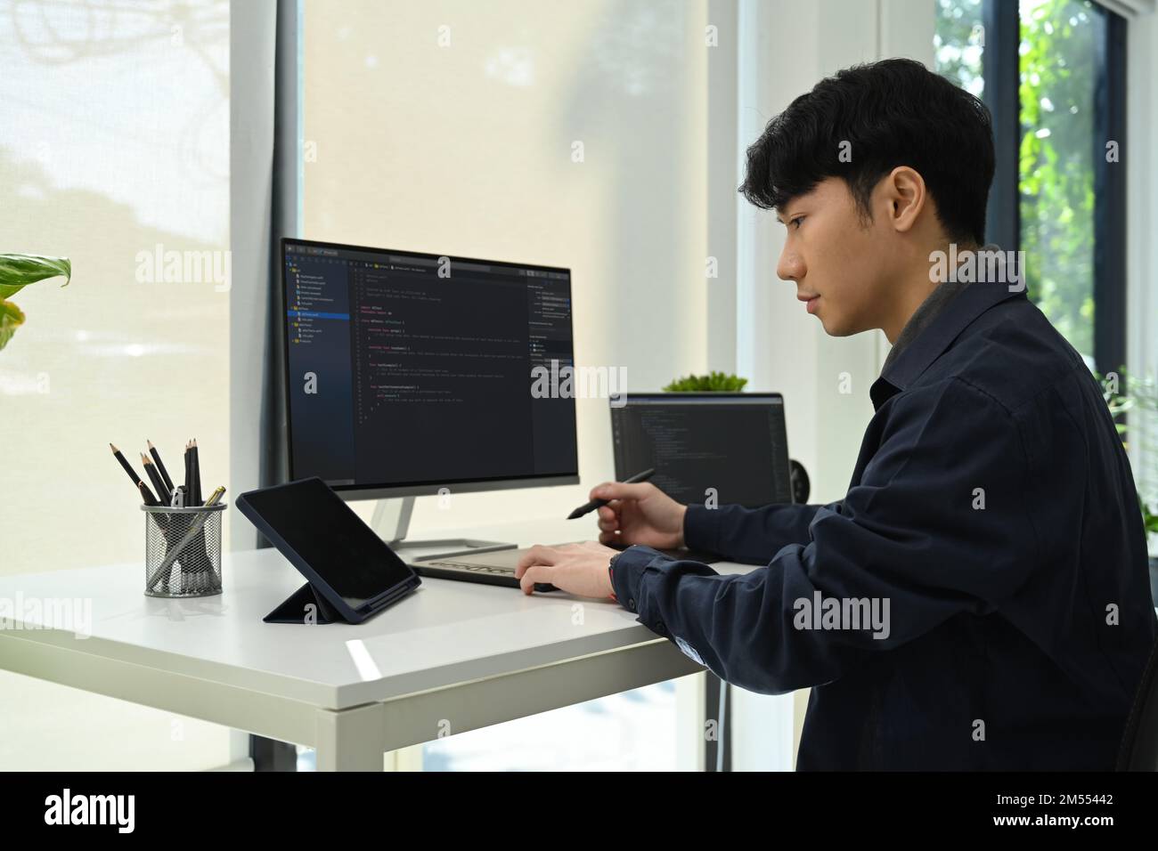 Uomo asiatico sviluppatore che lavora con dati codificati sullo schermo del computer. Sviluppo del concetto di tecnologie di programmazione e codifica Foto Stock