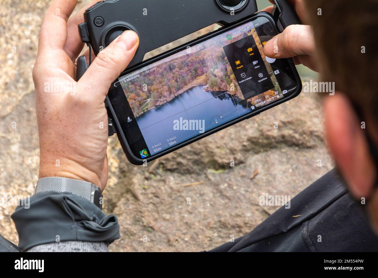 Uomo che vola drone sul lago di Monticolo in Alto Adige, Appiano, provincia di Bolzano, Trentino Alto Adige, Italia settentrionale-Europa Foto Stock