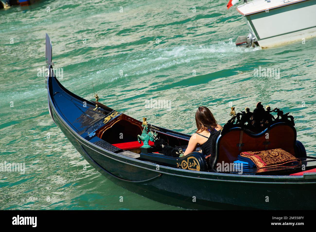 Dettaglio di una gondola nel grande canale con una giovane donna vista da dietro, Venezia, Italia Foto Stock