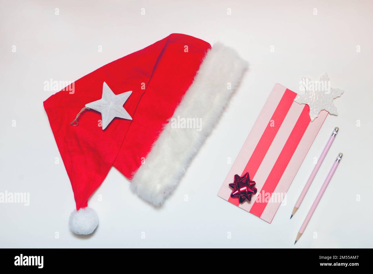 cappello di santa e lettera con matita. Lista dei desideri di Capodanno o Natale. Banner vacanza dall'alto Foto Stock