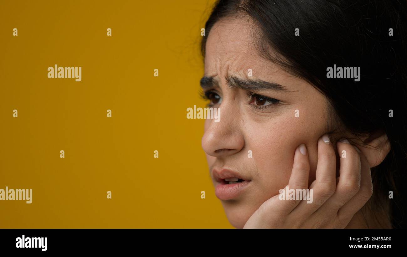Primo piano femmina in studio sfondo giallo indiano etnica donna ragazza signora malato soffrono di mal di denti infiammazione malata nelle gengive danno dentale infezione Foto Stock