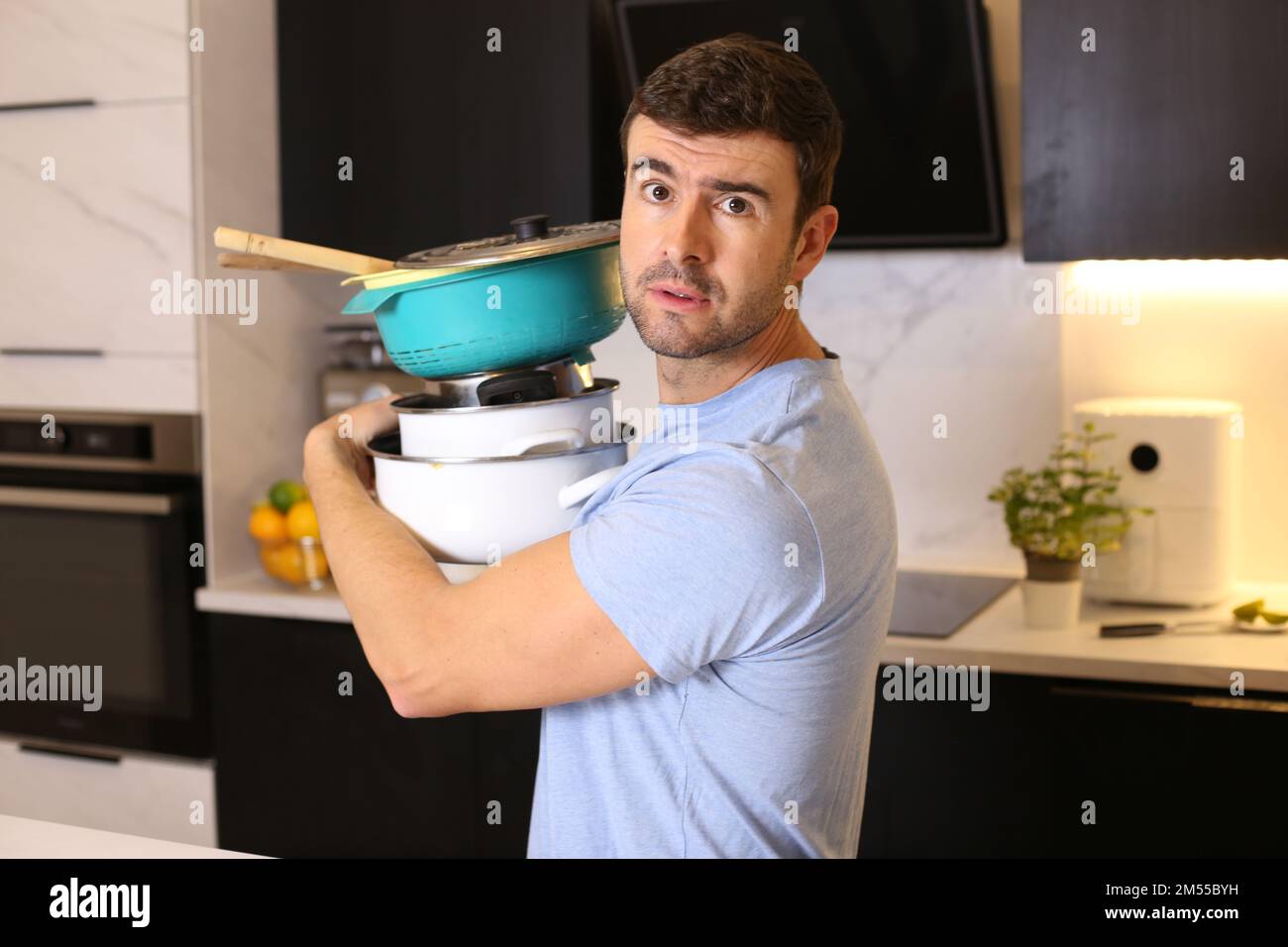 Uomo che cerca di organizzare la sua cucina Foto Stock