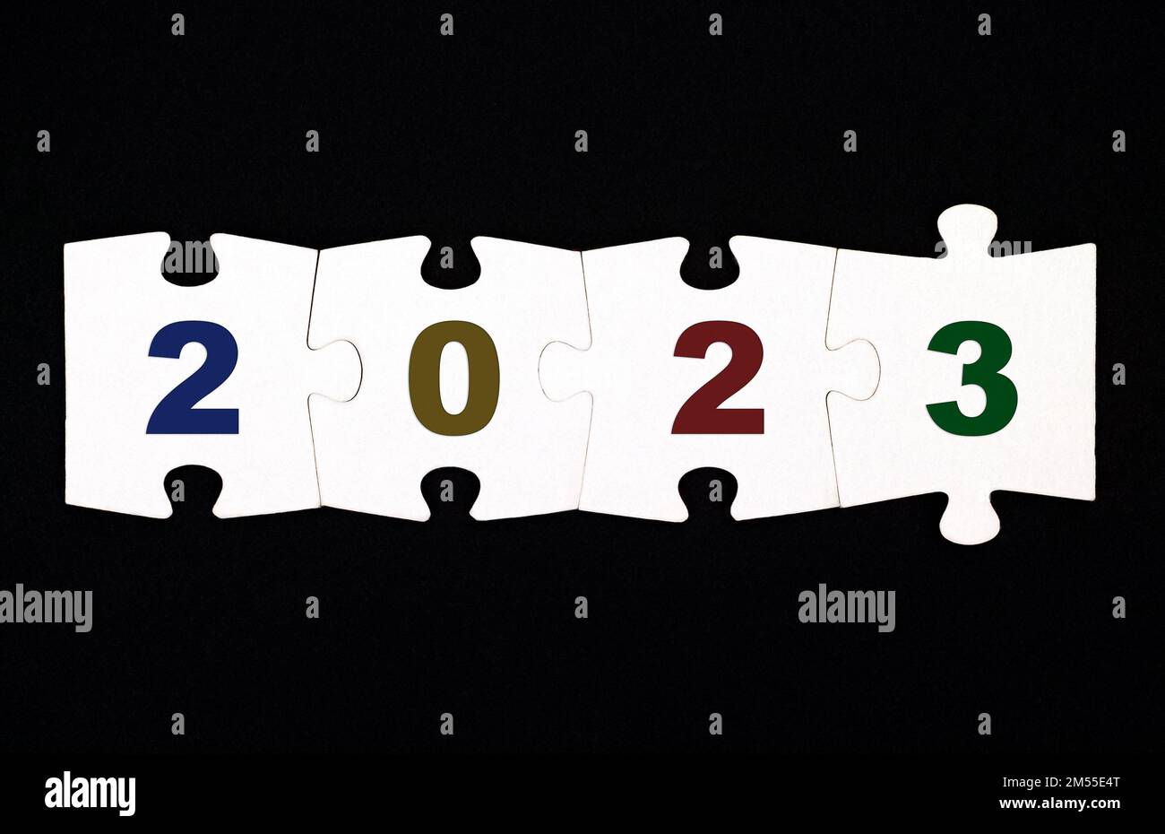 Quattro pezzi di un puzzle con i numeri 20223 sono collegati insieme su uno sfondo nero Foto Stock