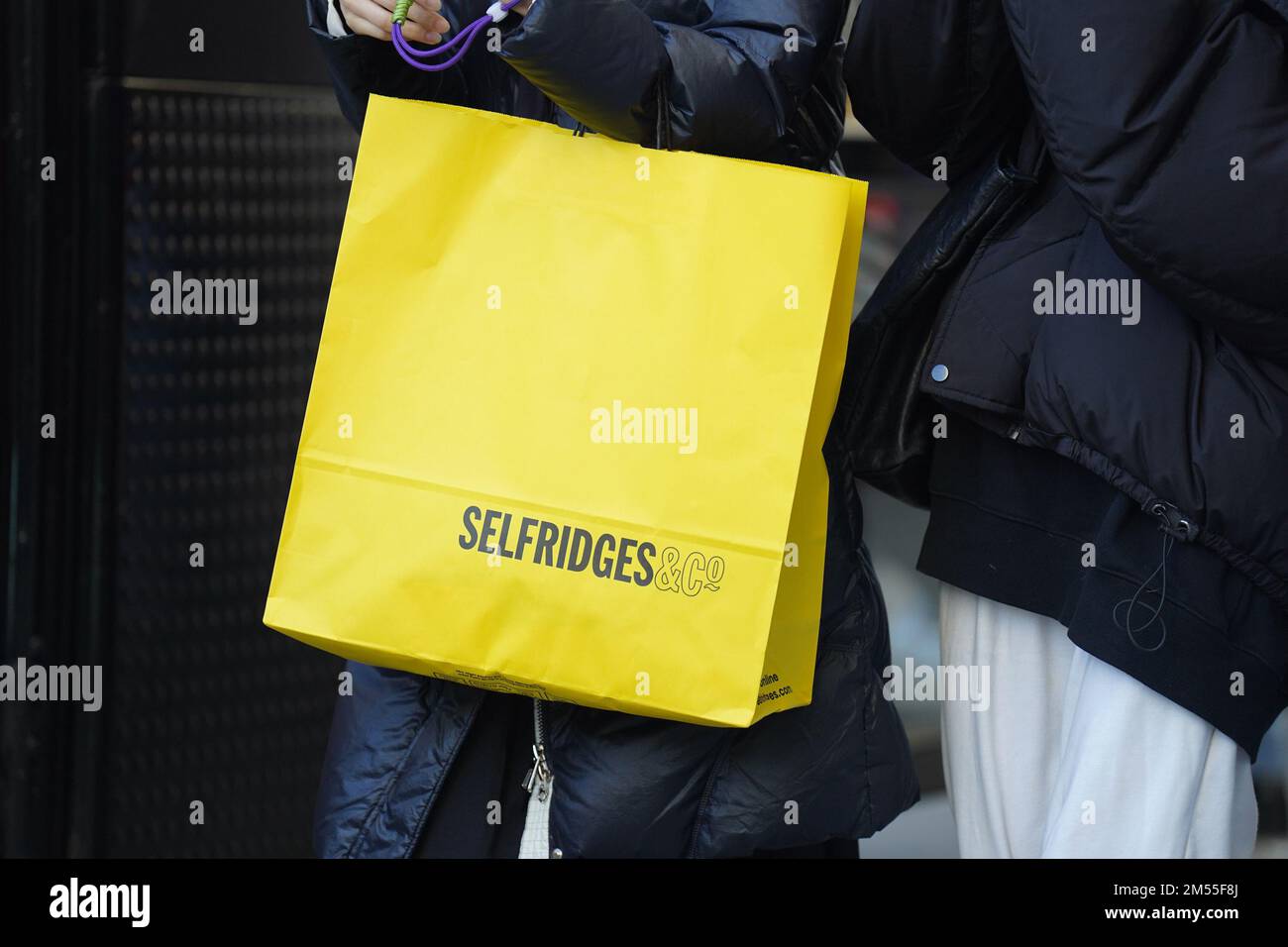 Gli acquirenti che trasportano borse per grandi magazzini Selfridges a Oxford Street, a Londra, durante le vendite del giorno di Santo Stefano. Gli acquirenti di Boxing Day cercheranno particolarmente difficile quest'anno per ottenere il miglior rapporto qualità/prezzo, visto che le bollette di tutti i giorni si alzano. Data immagine: Lunedì 26 dicembre 2022. Foto Stock