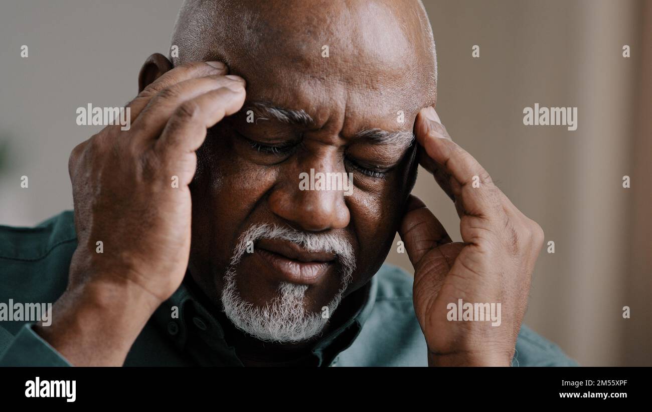 Primo piano triste sofferenza anziano afroamericano malato maligno sensazione di mal di testa emicrania cronica mal di testa mal di testa nonno multirazziale malsano massaggiante Foto Stock