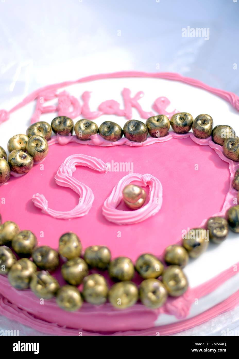 Primo piano verticale di una torta di compleanno rosa per il 50th° anniversario. Foto Stock